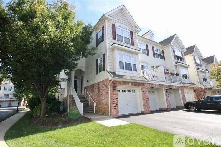 A two-story house with a brick foundation and a white garage door.