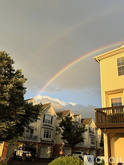 A rainbow appears in the sky over a residential area.