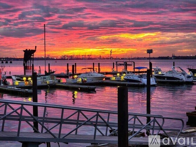 A dock with boats and a sunset in the background.