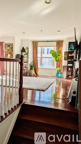 A living room with a white rug and a television on the right side.