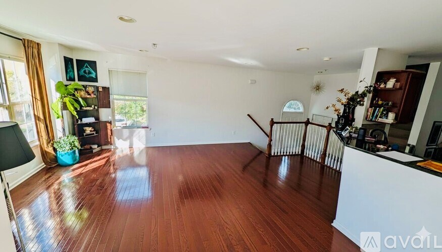 A living room with a wooden floor and a white wall.