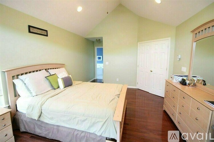 A bedroom with a bed, dresser, and mirror.