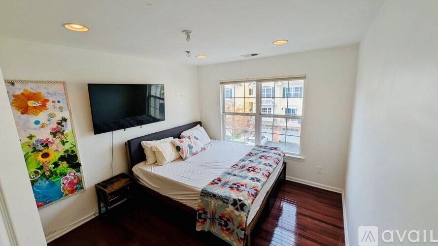 A bedroom with a bed, a TV, and a window.