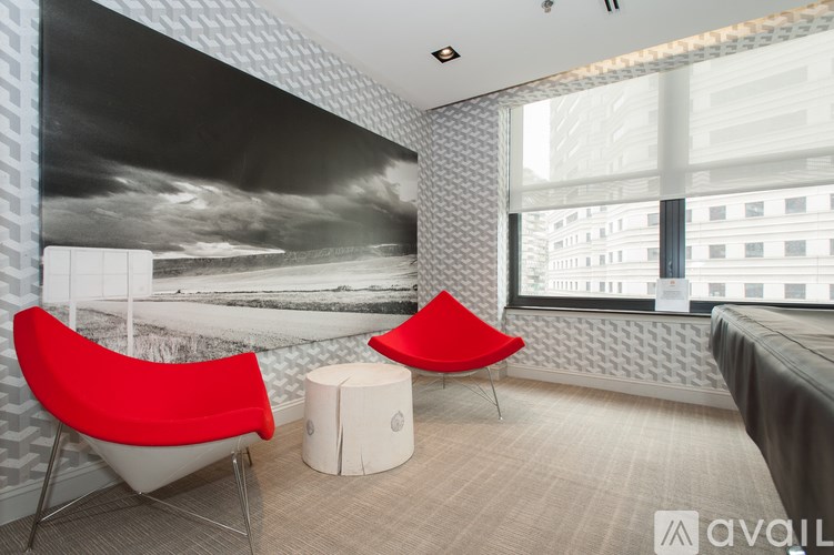 A room with a red chair and a white ottoman.