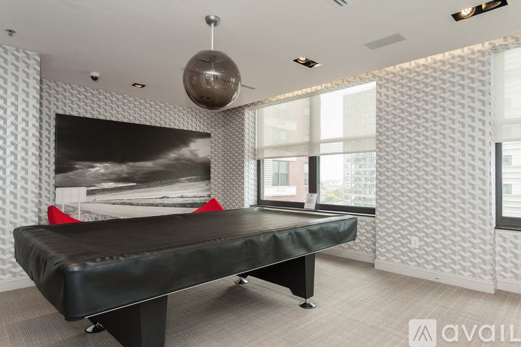 A room with a black massage table and a large picture on the wall.