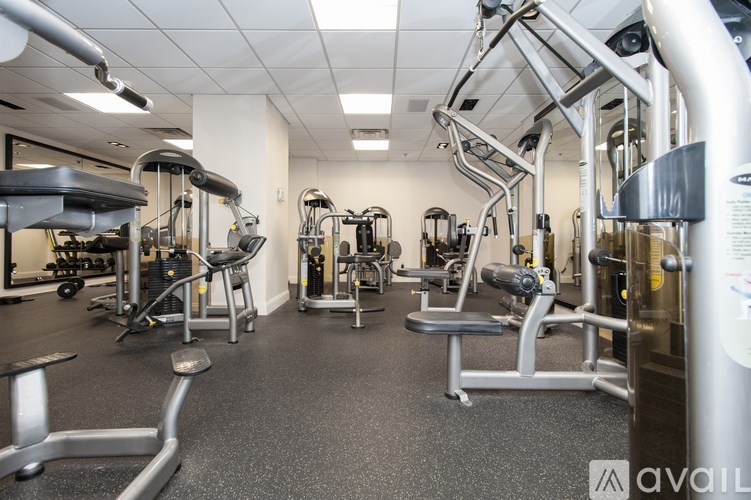 A gym with a variety of equipment including treadmills, weights, and exercise machines.