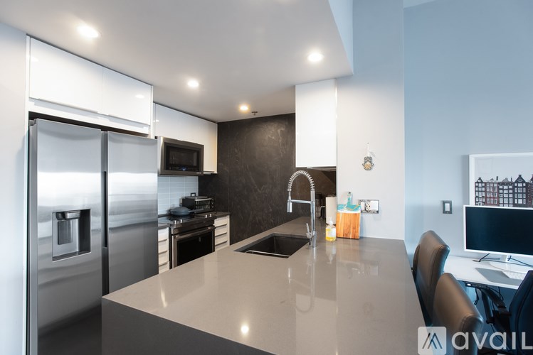 A modern kitchen with a large island and stainless steel appliances.