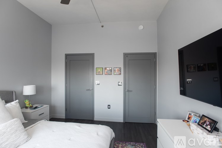 A bedroom with a bed, nightstand, and two doors.