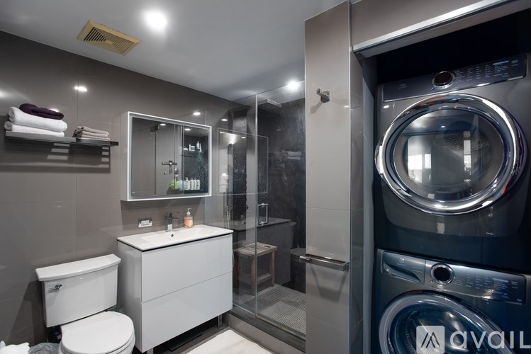 A modern bathroom with a washing machine built into the wall.