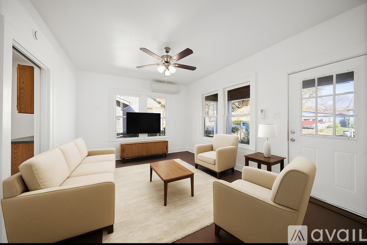 A living room with a beige sofa, two armchairs, and a coffee table.