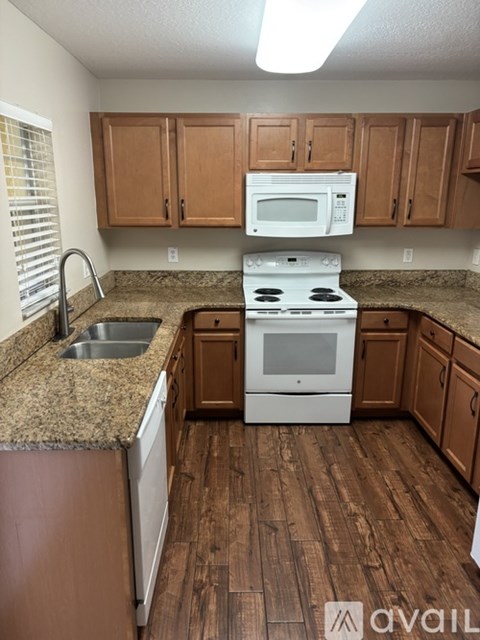 A kitchen with a white stove and wooden cabinets.