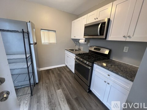 A kitchen with a black stove top oven and white cabinets.
