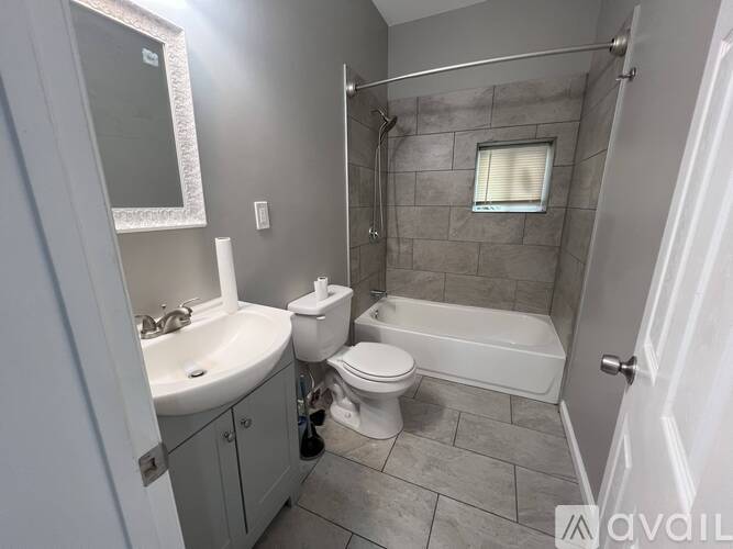 A bathroom with a toilet, sink, and bathtub.