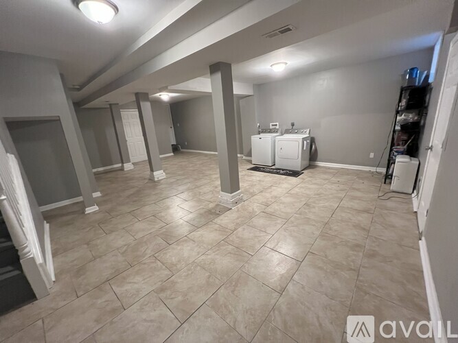 A spacious room with tiled flooring and a large window.