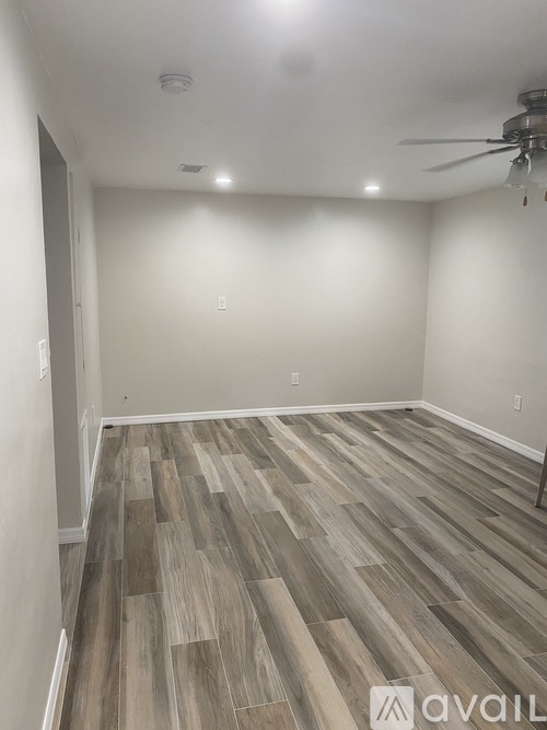 A room with wooden flooring and a ceiling fan.