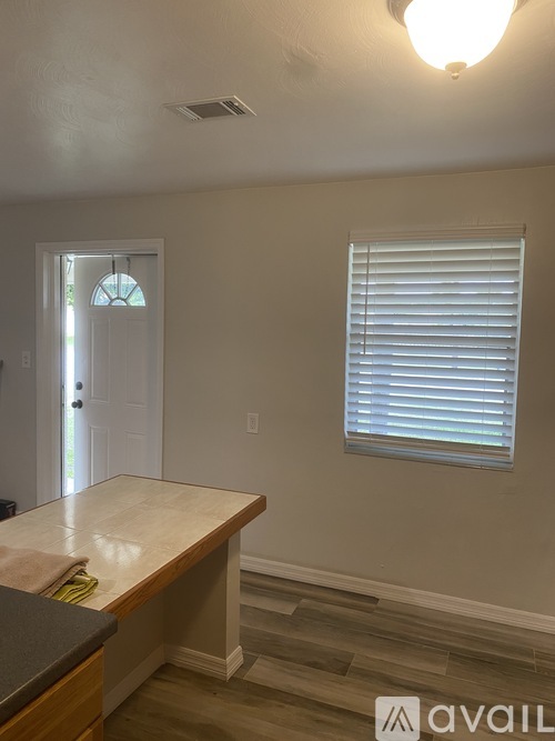 A kitchen counter with a towel on it and a window with blinds.