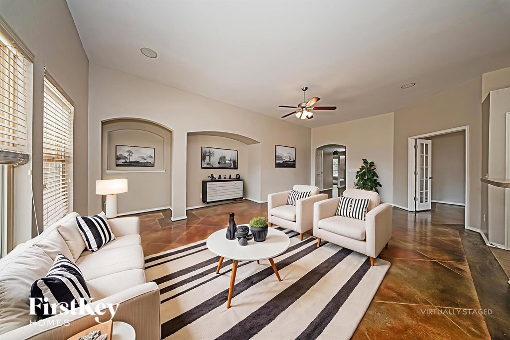 A living room with a white couch and a striped rug.