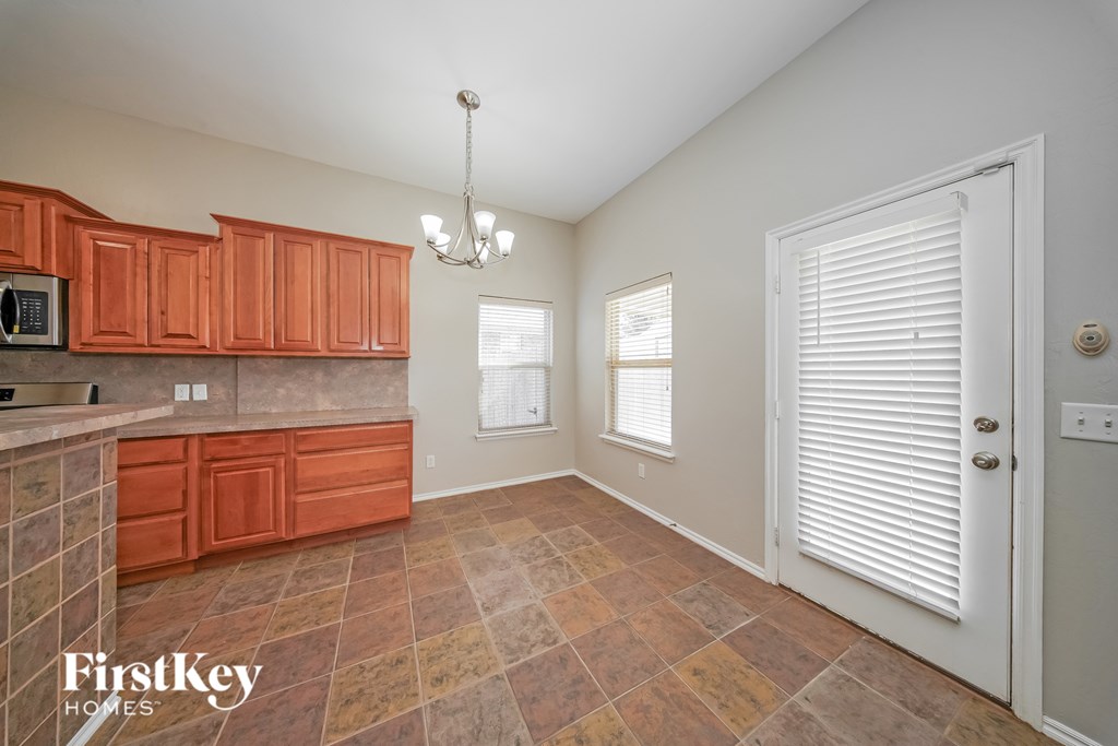 A kitchen with orange cabinets and a tiled floor.
