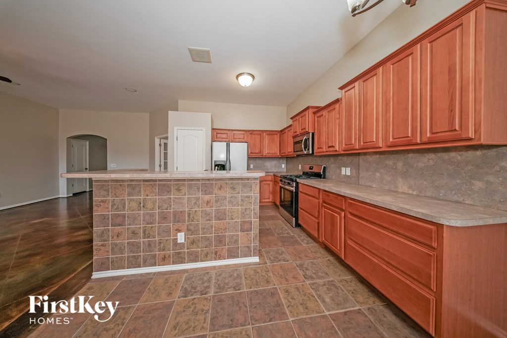 A kitchen with wooden cabinets and a tile backsplash.