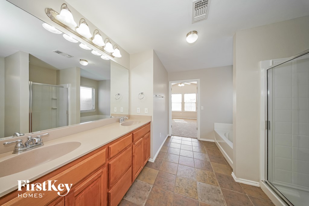 A bathroom with a large mirror and a walk-in shower.