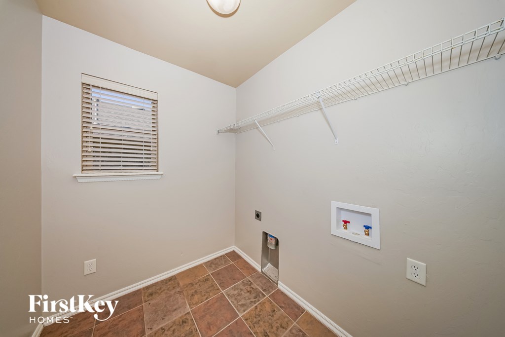 A room with a tile floor and a window with blinds.