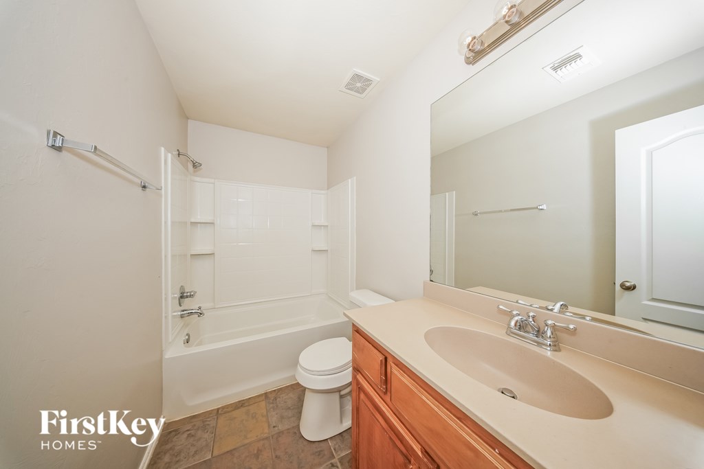A white bathroom with a toilet, sink, and bathtub.
