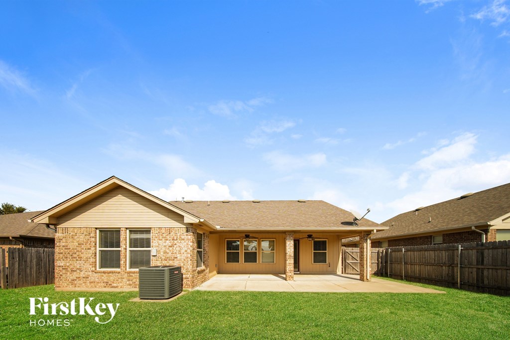 A house with a brown roof and a fence in front of it.