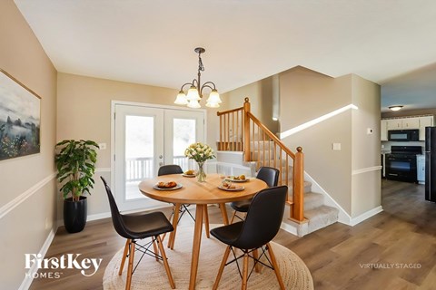 A dining room with a wooden table and chairs.