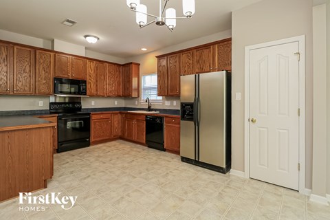 A kitchen with wooden cabinets and a refrigerator.