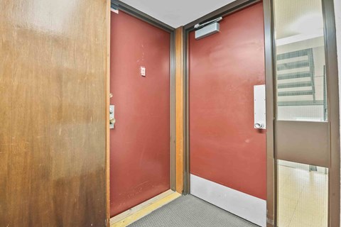 A red door with a silver handle and a silver lock.