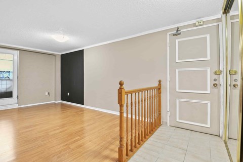A room with a wooden staircase and a white door.