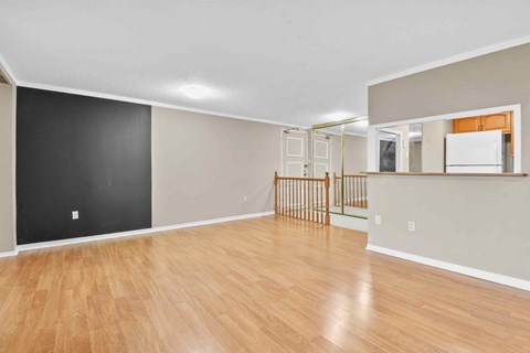A room with wooden flooring and white walls.