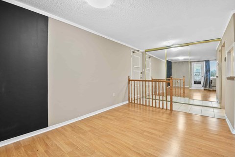 A room with wooden flooring and a black wall.