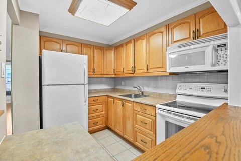 A kitchen with wooden cabinets and white appliances.
