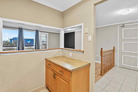 A kitchen area with a wooden counter and cabinets.
