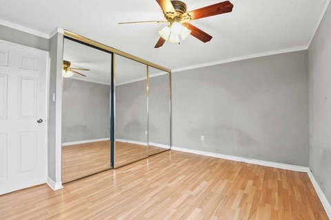 A room with a ceiling fan and a sliding door.