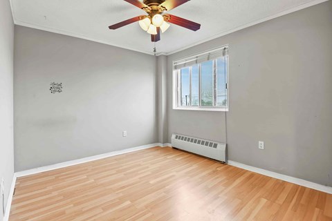A room with a ceiling fan and a window.