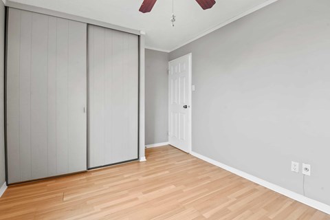 A room with a sliding door and a ceiling fan.