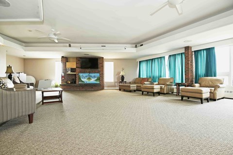 A living room with a television, couches, and a fireplace.