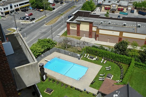 A pool in a backyard with a building in the background.