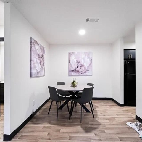A dining room with a table and chairs.
