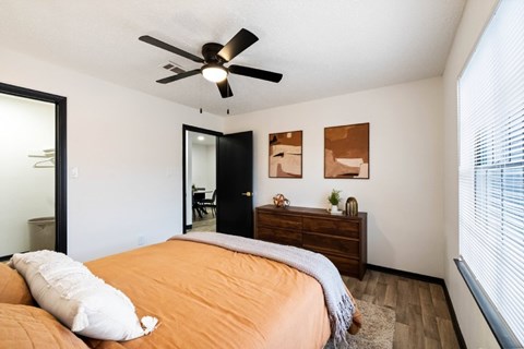 A bedroom with a bed, dresser, and mirror.