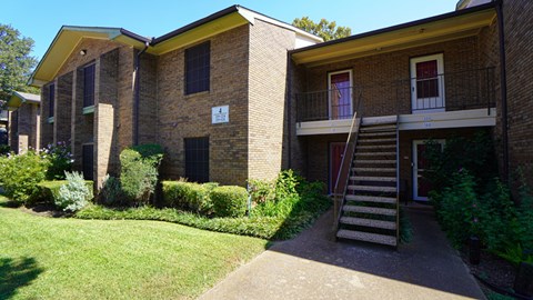 A building with a yellow roof and a staircase leading to the entrance.