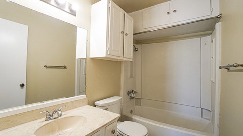 A bathroom with a sink, toilet, and bathtub.