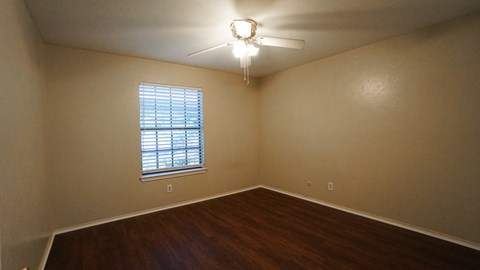 A room with a window and a ceiling fan.