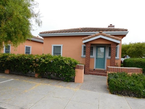 A small house with a green door and a grey window.