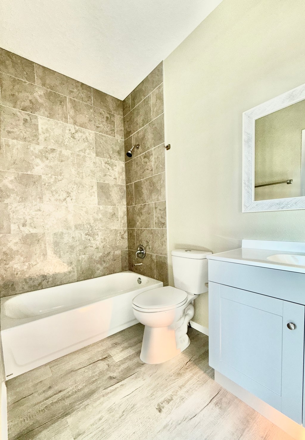 A bathroom with a tub, toilet, and sink.