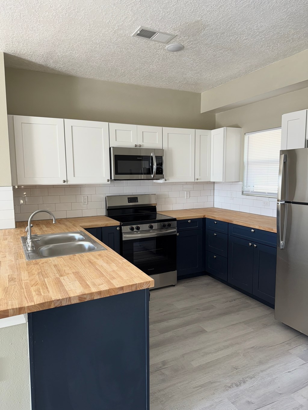 A kitchen with a sink, stove, and refrigerator.