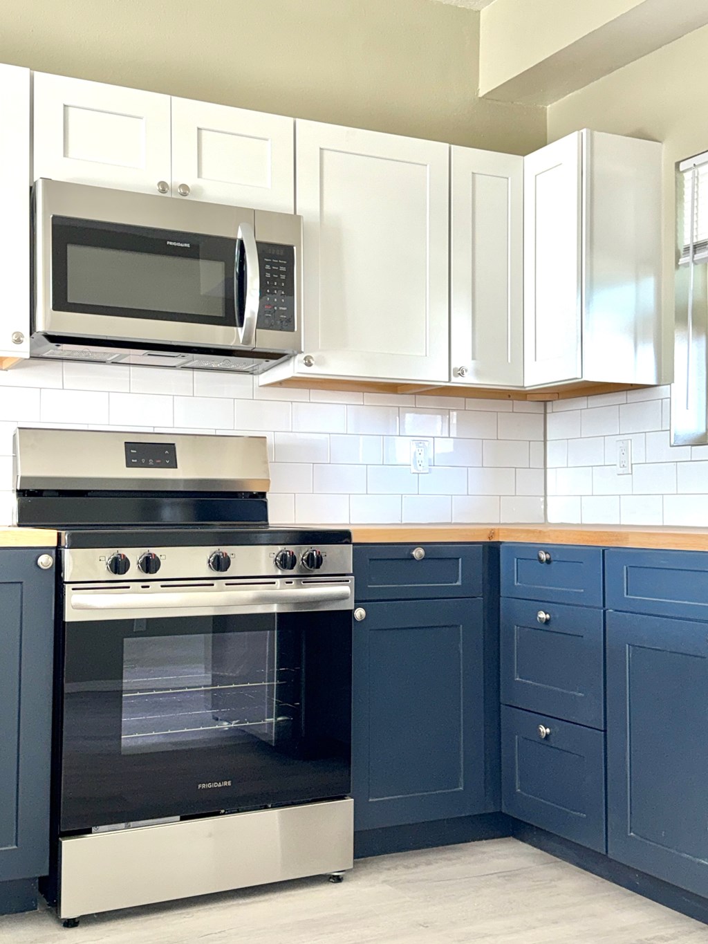 A kitchen with a black oven and white cabinets.