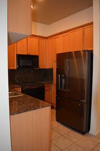 A kitchen with a refrigerator and microwave.